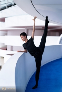 Dancer Zhiheng Li peeks at the lower level as he warms up. (Photo by Kenji Kobayashi)